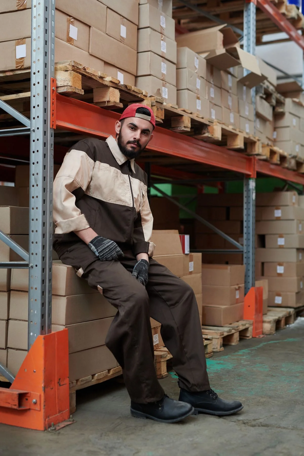 Warehouse worker beside racks of stocked and wrapped goods